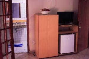 Cette chambre dispose d'une télévision et d'une armoire avec un ordinateur. dans l'établissement Pousada Riacho da Serra, à Penedo