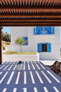 a patio with a blue table and chairs and a house at Villa Giulia, seaview villa in Ios Chora