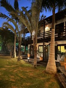 a group of palm trees in front of a building at Studios Malakoopa - Praia do Rosa in Praia do Rosa