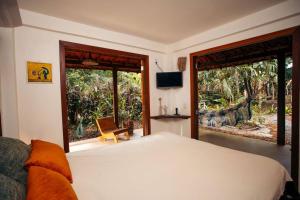 a bedroom with a large bed and a large window at Casa aconchegante na Bahia para viver uma experiência de hospedagem pertinho da praia in Marau