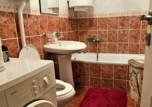 een badkamer met een toilet, een wastafel en een bad bij Anastasija in Novi Sad