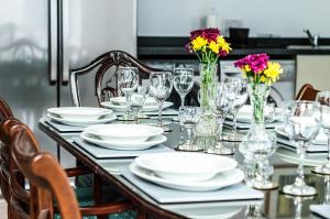 einen Tisch mit Tellern, Gläsern und Blumen darauf in der Unterkunft The Heart of Newington in Edinburgh