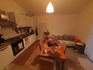 una cocina y una sala de estar con una mesa con flores. en SWEET DAYS, en Mondragone