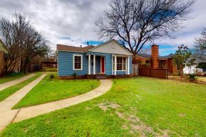 une petite maison bleue avec une pelouse dans l'établissement The Modern Farmhouse Cottage, à Wichita Falls
