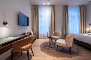 een hotelkamer met een bed, een bureau en stoelen bij ONE TWO FOUR - Hotel & Spa in Gent