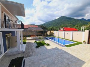 a backyard with a swimming pool and a house at Rest Paradise Villa Gabala in Gabala