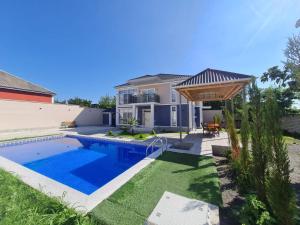a backyard with a swimming pool and a house at Rest Paradise Villa Gabala in Gabala