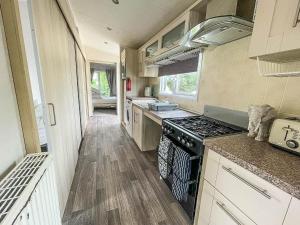 a kitchen with a stove and a counter top at Lovely Wheelchair Friendly Caravan At Skipsea Sands In Yorkshire Ref 41167wf in Barmston
