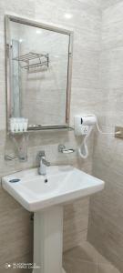 bagno con lavandino bianco e specchio di River View Villas a Qusar