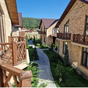a path between two buildings with a wooden fence at River View Villas in Qusar