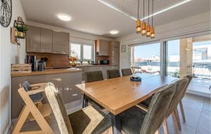 a kitchen and dining room with a wooden table and chairs at Gorgeous Home In Vrsi in Vrsi