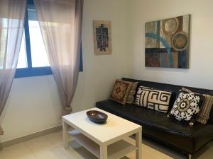 a living room with a black couch and a table at Casa Barbara El Cotillo in Cotillo