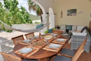 a wooden table with chairs and a hammock in a living room at Happy Friar's in Friar's Bay