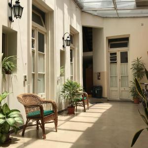 Reina Madre Hostel في بوينس آيرس: ساحة مع كراسي ونباتات في مبنى