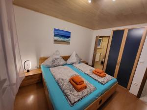 una camera da letto con un letto e asciugamani arancioni di Ferienwohnung Mein Zuhause a Pottenstein