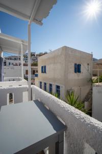 a balcony with a table and a building at Eleios Hotel Serifos in Livadi