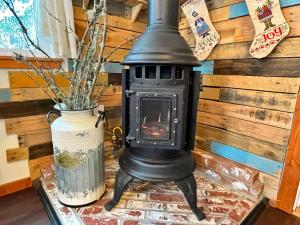 a stove sitting on a table next to a vase at Kataluma Inn, Sandpoint, Idaho - entire cozy cabin in Sandpoint