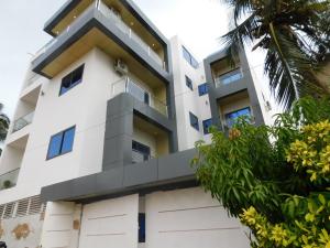 an exterior view of a white building with blue windows at Résidence Bouba Bamako in Bamako