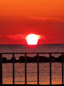 einen Sonnenuntergang über dem Meer mit der Sonne am Himmel in der Unterkunft Loft a 30 metri dalla Spiaggia in LʼAnnunziata