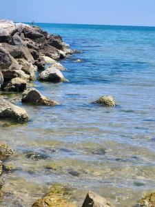 eine Gruppe Felsen im Wasser in der Nähe des Ozeans in der Unterkunft Loft a 30 metri dalla Spiaggia in LʼAnnunziata