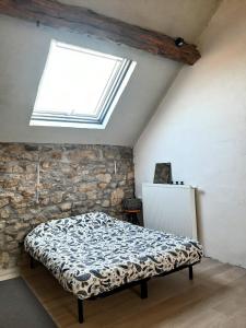 um quarto com uma cama e uma clarabóia em Guesthouse Le petit chapeau em Durbuy