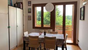 una sala da pranzo con tavolo, sedie e finestra di Como Lake Milano Dream Apartment a Guanzate