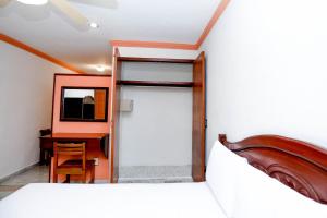 1 dormitorio con cama, escritorio y ordenador en Hotel Avenida Cancun, en Cancún