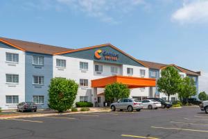 a hotel with cars parked in a parking lot at Comfort Suites in Elgin