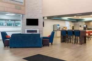 a lobby with blue chairs and a bar with a fireplace at Comfort Suites Elgin in Elgin