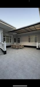 une grande pièce vide avec des tables et des chaises. dans l'établissement LOONA FAMILY HOSTEL, à Tachkent