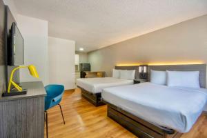 a hotel room with two beds and a tv at Studio 6-Austin, TX - Midtown in Austin