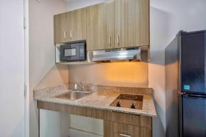 a small kitchen with a sink and a microwave at Studio 6-Austin, TX - Midtown in Austin