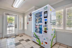 a large white refrigerator in a room with windows at Studio 6-Austin, TX - Midtown in Austin