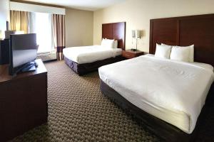 a hotel room with two beds and a flat screen tv at Comfort Inn & Suites Mount Pocono in Mount Pocono