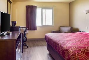 a hotel room with a bed and a flat screen tv at Econo Lodge in Newport