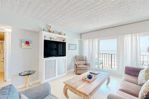 a living room with a tv and a couch and a table at Ocean Bliss By the Sea in Galveston