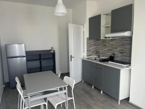 a kitchen with a table and chairs and a refrigerator at Residence Blumarine in Ostuni