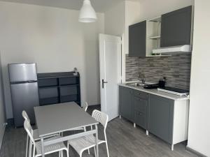 La cuisine est équipée d'une table, de chaises et d'un réfrigérateur. dans l'établissement Residence Blumarine, à Ostuni