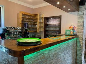 a bar with a green plate on a counter at Hostel in picerija Špajza in Mojstrana