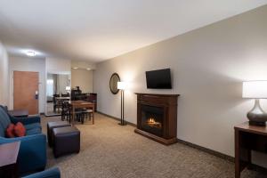 a living room with a fireplace and a tv at Comfort Suites Suffolk - Chesapeake in Suffolk