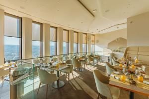 a restaurant with tables and chairs and windows at Radisson Blu Hotel, Lyon in Lyon