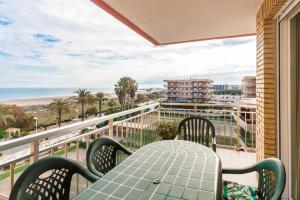 un tavolo e sedie su un balcone con vista sulla spiaggia di Vacaciones Canet Playa - en primera linea a Canet de Berenguer