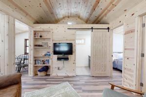 un soggiorno con pareti in legno e TV a schermo piatto di Big Pine Retreat a Crescent