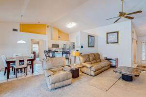 a living room with two couches and a table at Palm Bay Getaway in Palm Bay