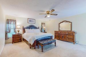 a bedroom with a bed and a mirror and a ceiling fan at Palm Bay Getaway in Palm Bay