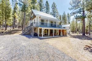 a large white house in the middle of a forest at Hibernation Station at Big Pine Retreat in Crescent