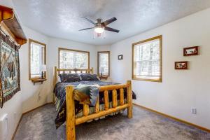 a bedroom with a wooden bed and a ceiling fan at Hibernation Station at Big Pine Retreat in Crescent