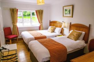 a hotel room with two beds and a window at Rockfield Manor B&B, Knock in Knock