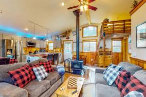 uma sala de estar com um sofá e um fogão a lenha em Loon Lake Retreat em Loon Lake