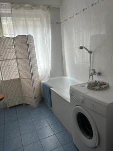 2 Zimmer Wohnung 1min Messe Köln في كولونيا: حمام مع غسالة وحوض استحمام